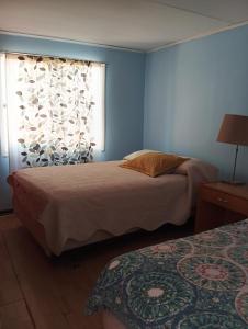 a blue bedroom with two beds and a window at Lodge Gabriela Mistral in Pisco Elqui +13 photos