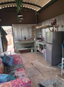 a kitchen with a refrigerator and a couch in a room at Pumba's Den Kranspoort in Winterkamp +59 photos