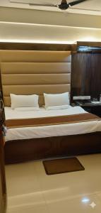 a bedroom with a large bed with a wooden headboard at Raghunath Jammu in Jammu