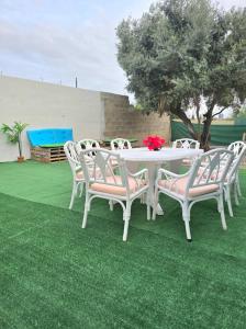a white table and chairs on a green lawn at La Casita de Beni Valencia in Valencia