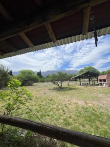 a view of a field with a building in the distance at Reserva Ichacuna in Los Hornillos