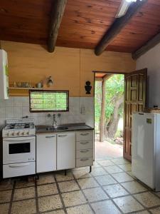 a kitchen with a stove and a sink and a refrigerator at Reserva Ichacuna in Los Hornillos