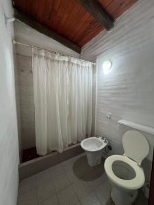 a white bathroom with a toilet and a sink at Reserva Ichacuna in Los Hornillos +8 photos