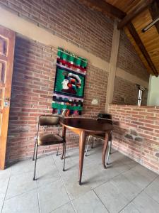 a table and two chairs on a brick wall at Reserva Ichacuna in Los Hornillos
