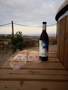a bottle of wine and glasses sitting on a wooden table at Finca La Suerte in Chimiche +11 photos