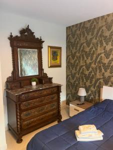 a bedroom with a dresser and a blue bed at Conte di Cavour in Rocca di Papa