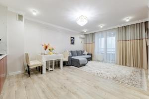 ein Wohnzimmer mit Sofa und Tisch in der Unterkunft Шикарные апартаменты возле Хан Шатыр in Astana