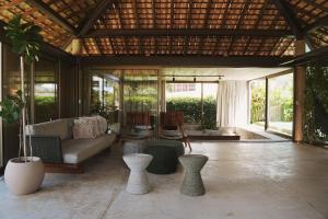 a living room with a couch and chairs and windows at Casa com piscina aquecida, cozinheira, 30m do mar in Barra do Camaragibe