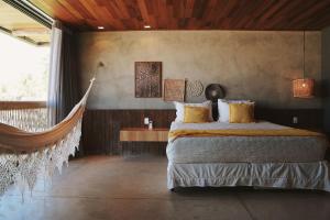 a bedroom with a bed and a hammock in it at Casa com piscina aquecida, cozinheira, 30m do mar in Barra do Camaragibe