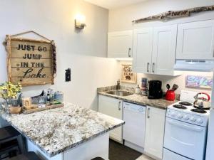 eine Küche mit weißen Schränken und einer Arbeitsplatte in der Unterkunft A113 Loon Mountain Studio Apartment with Pool and Hot Tub in Lincoln + 48 Fotos