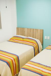 een kamer met twee bedden met kleurrijke dekens erop bij Condominio Alegre Amanecer in Santa Cruz Huatulco