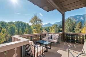 a balcony with chairs and a table and a view of the mountains at Obertal Inn in Leavenworth