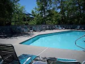 ein großer Swimmingpool mit Stühlen und einem Tisch in der Unterkunft A113 Loon Mountain Studio Apartment with Pool and Hot Tub in Lincoln