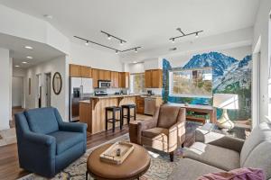 a living room with a couch and chairs and a kitchen at Obertal Inn in Leavenworth