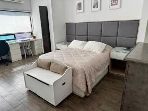 Un dormitorio con una cama, un escritorio y una silla. en PLAZA VERANO, en Monterrey