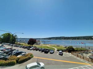 ein Parkplatz mit Autos, die neben einem Wasserkörper geparkt sind in der Unterkunft Liberty Bay Loft with Water views in Poulsbo