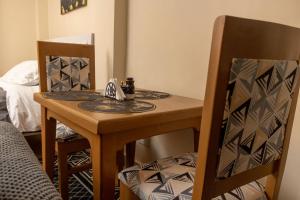 a dining room table and chairs with a small table and chairs at JAS Stays in Nanyuki