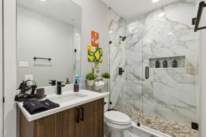 a bathroom with a sink and a toilet and a shower at The Larimar 2BD TownHouse 7ST Walkable in Fort Worth +44 photos