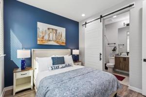 a blue bedroom with a bed and a bathroom at The Larimar 2BD TownHouse 7ST Walkable in Fort Worth