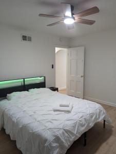 a bedroom with a white bed with a ceiling fan at Oilgate at Parkgate in Akron