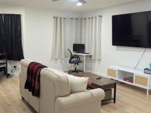 a living room with a couch and a flat screen tv at Oilgate at Parkgate in Akron