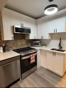 a kitchen with white cabinets and a stove top oven at Historic Downtown Apartment 2BD Retreat in London