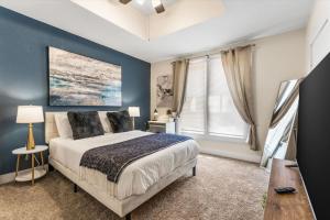 a bedroom with a bed and a blue wall at Uplifting 2BD House in the heart of FortWorth in Fort Worth