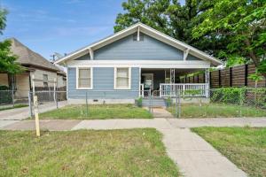 a blue house with a fence in front of it at Uplifting 2BD House in the heart of FortWorth in Fort Worth