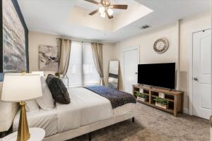 a bedroom with a bed and a flat screen tv at Uplifting 2BD House in the heart of FortWorth in Fort Worth