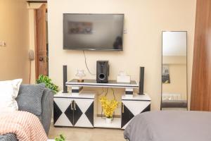 a living room with a television on a wall at JAS Stays in Nanyuki