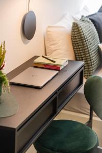 einen Schreibtisch mit einem Laptop und einem Stuhl neben einem Bett in der Unterkunft Raciborska Old Town in Gliwice