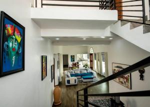 a living room with a bed and a staircase at Elegant Lakeside Villa in Kibuye, Rwanda in Mwendo +10 photos