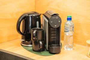 eine Kaffeemaschine auf einer Theke mit einer Flasche Wasser in der Unterkunft Raciborska Old Town in Gliwice