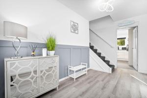 a living room with a staircase and a dresser at "Chez Nous" Perfect for contractors or families Sleeps 8 in Halesowen