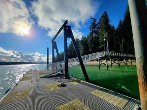 eine Brücke über ein Gewässer mit grünem Wasser in der Unterkunft Beachfront cabin, dock, water views in Point White