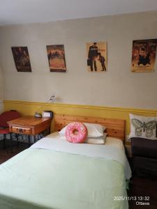 un donut rose assis au-dessus d'un lit dans l'établissement Ottawa University center near train Station & Parliament, à Ottawa