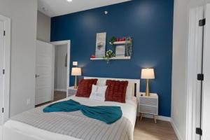 a bedroom with blue walls and a bed with red pillows at A La mode 2BD Townhouse 7TH St walkable in Fort Worth