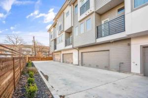 a house with two garage doors and a fence at A La mode 2BD Townhouse 7TH St walkable in Fort Worth