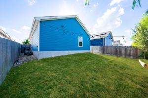 a yard with a blue building and a fence at TONKA in Austin