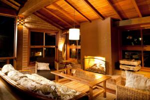 uma sala de estar com um sofá e uma lareira em Pousada do Quilombo em São Bento do Sapucaí