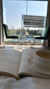an open book with a cup of coffee on a table at لامور فيلا in Sohar