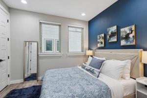 a bedroom with a bed with a blue wall at The Opal 2BD TowenHouse 7ST Walkable in Fort Worth