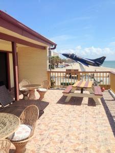 a patio with a table and chairs and a plane at Capri Beach Hotel in Corpus Christi