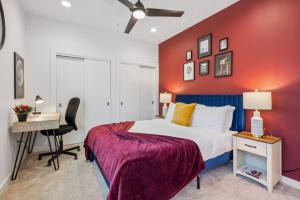 - une chambre dotée d'un mur rouge avec un lit et un bureau dans l'établissement Aquara 2BD Townhouse DownTown Walkable, à Dallas