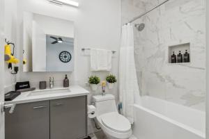 La salle de bains blanche est pourvue d'un lavabo, de toilettes et d'une baignoire. dans l'établissement Aquara 2BD Townhouse DownTown Walkable, à Dallas 32 autres photos