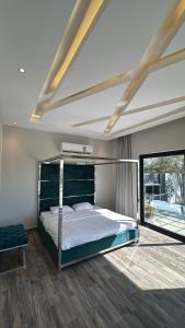 a bedroom with a bed and a large window at لامور فيلا in Sohar