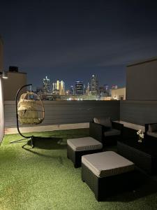 une terrasse sur le toit avec vue sur la ville la nuit dans l'établissement The Indigo 2BDTownhouse DownTown Walkable, à Dallas