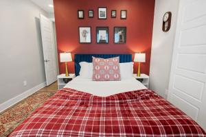 a bedroom with a bed with a red wall at The Charm 2BD In the Heart of Magnolia in Fort Worth