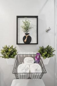 a basket with towels and a picture on a wall at The Charm 2BD In the Heart of Magnolia in Fort Worth +38 photos