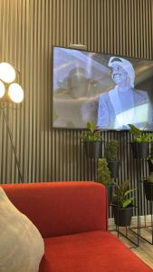 a living room with a tv and a red couch at لامور فيلا in Sohar